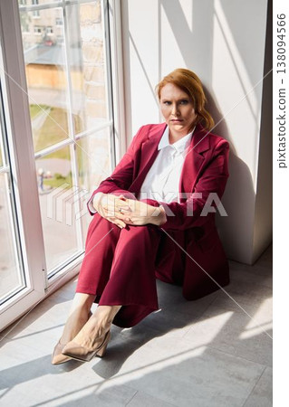Person with red hair wearing elegant attire in studio environment 138094566