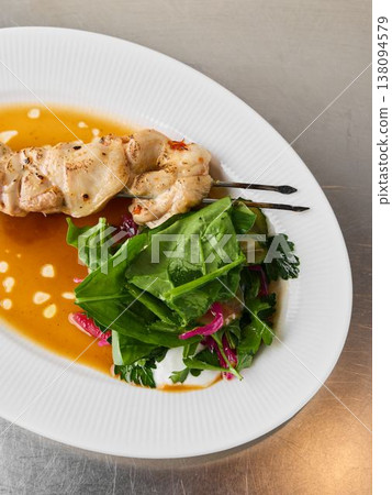 Closeup of grilled chicken with wilted spinach and citrus dressing 138094579