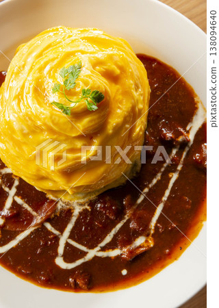 Fluffy and creamy omelet rice with demi-glace sauce, cream decoration, and parsley garnish - a classic Western-style dish. Fluffy and creamy omelet rice with demi-glace sauce, cream decoration, and parsley garnish - a classic Western-style dish. 138094640