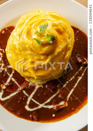 Fluffy and creamy omelet rice with demi-glace sauce, cream decoration, and parsley garnish - a classic Western-style dish. 138094641