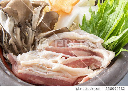 雞肉火鍋佐舞茸菇、水菜、胡蘿蔔和白蘿蔔。色彩繽紛的日式火鍋盛放在陶鍋中,讓人聯想到冬日餐桌的景象。 雞肉火鍋佐舞茸菇、水菜、胡蘿蔔和白蘿蔔。色彩繽紛的日式火鍋盛放在陶鍋中,讓人聯想到冬日餐桌的景象。 138094682