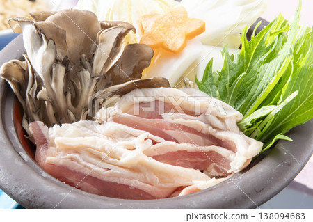 雞肉火鍋佐舞茸菇、水菜、胡蘿蔔和白蘿蔔。色彩繽紛的日式火鍋盛放在陶鍋中,讓人聯想到冬日餐桌的景象。 雞肉火鍋佐舞茸菇、水菜、胡蘿蔔和白蘿蔔。色彩繽紛的日式火鍋盛放在陶鍋中,讓人聯想到冬日餐桌的景象。 138094683