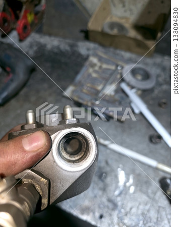 Industrial Igniter Part Being Held in Hand During Repair in Workshop Industrial Igniter Part Being Held in Hand During Repair in Workshop 138094830