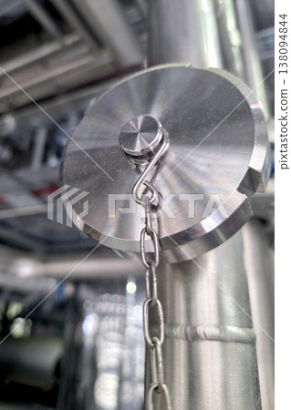 Stainless Steel Pipe Plug With Chain Attached in Industrial Setting Stainless Steel Pipe Plug With Chain Attached in Industrial Setting 138094844