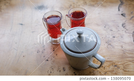 Morning ritual red herbal infusion two transparent cups white teapot natural light wooden surface cozy home beverage 138095070