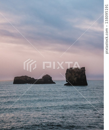 Dramatic seascape with rock formations at Dyrholaey, South Iceland, under a bright sky 138095191