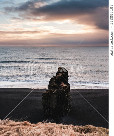 Arnardrangur sea stack on Reynisfjara black sand beach, South Iceland. Arnardrangur sea stack on Reynisfjara black sand beach, South Iceland. 138095195