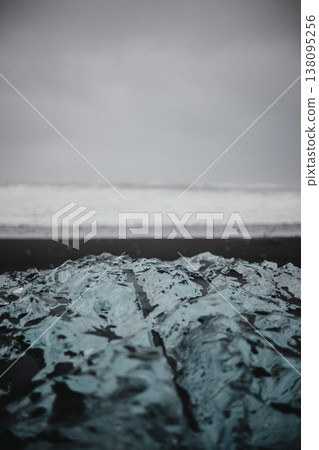 Close-up of glistening ice on Diamond Beach black sand, South Iceland. Close-up of glistening ice on Diamond Beach black sand, South Iceland. 138095256