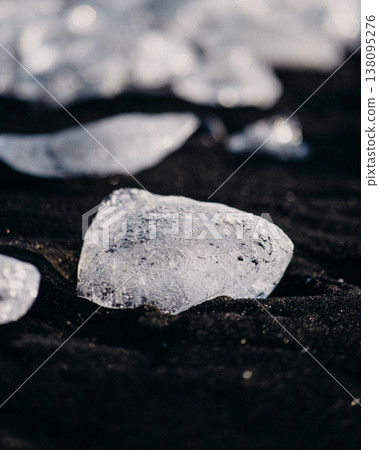 Close-up of glistening ice fragments on the black sand of Diamond Beach (Breidamerkursandur), South Iceland. Close-up of glistening ice fragments on the black sand of Diamond Beach (Breidamerkursandur), South Iceland. 138095276
