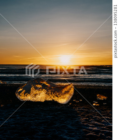 Golden sunset illuminating glacial ice on Diamond Beach (Breidamerursandur), South Iceland. Golden sunset illuminating glacial ice on Diamond Beach (Breidamerursandur), South Iceland. 138095281