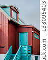 Teal and maroon wooden house with unique architectural details. 138095403