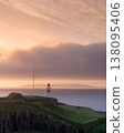 Sunset illuminates lighthouse on Torshavn dramatic coastline 138095406