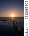 Radiant sunset viewed from a ferry deck, reflecting on wet surfaces 138095408