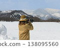 A woman taking pictures of snow-covered mountains 138095560