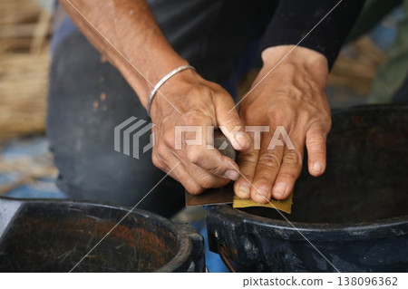 A man taking care of his plastering trowel A man taking care of his plastering trowel 138096362