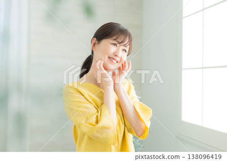 窗邊站著一位六十多歲的婦女 窗邊站著一位六十多歲的婦女 138096419