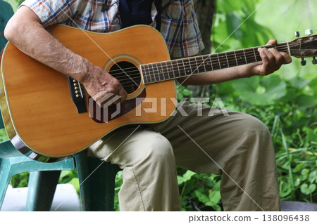 A man playing an acoustic guitar 138096438