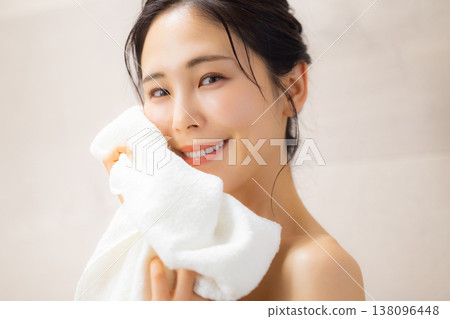 一位年輕女子洗完澡後用毛巾擦臉。 138096448