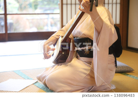 A woman playing a shamisen A woman playing a shamisen 138096483