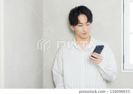 看他的智能手機的一個年輕人 看他的智能手機的一個年輕人 138096633