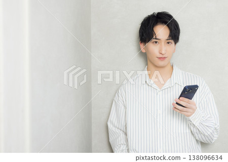 A young man looking at his smartphone A young man looking at his smartphone 138096634