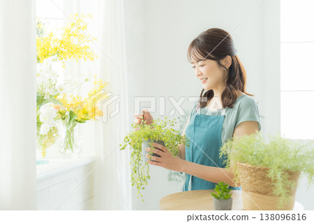 Woman arranging flowers on the windowsill 138096816