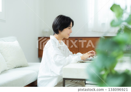 A woman watching a computer at home A woman watching a computer at home 138096921