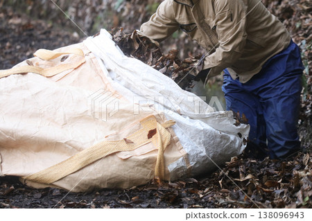 A man collecting fallen leaves 138096943