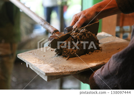A man painting a clay wall 138097444