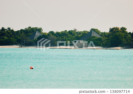 Classic Maldives island landscape on a sunset, azure water, white sand, palm trees on the shore 138097714