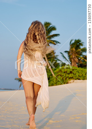 A beautiful tanned girl in a swimsuit runs along a white beach at sunset in the Maldives, she is happy, posing for a photographer A beautiful tanned girl in a swimsuit runs along a white beach at sunset in the Maldives, she is happy, posing for a photographer 138097730