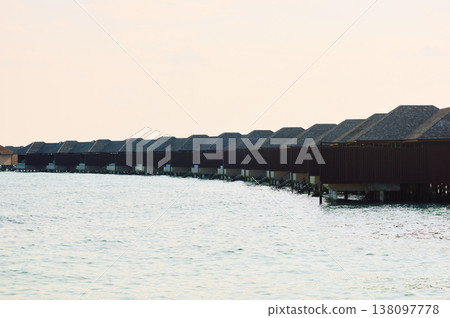 Classic Maldives island landscape on a sunset, azure water, white sand, palm trees on the shore Classic Maldives island landscape on a sunset, azure water, white sand, palm trees on the shore 138097778
