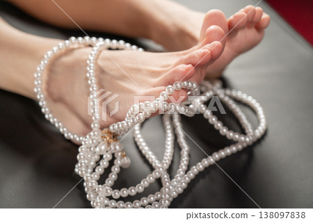 Foot fetish. Bare female feet with pearl beads. Foot fetish. Bare female feet with pearl beads. 138097838