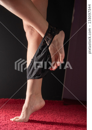 Foot fetish. A woman takes off her black lace panties. Foot fetish. A woman takes off her black lace panties. 138097844