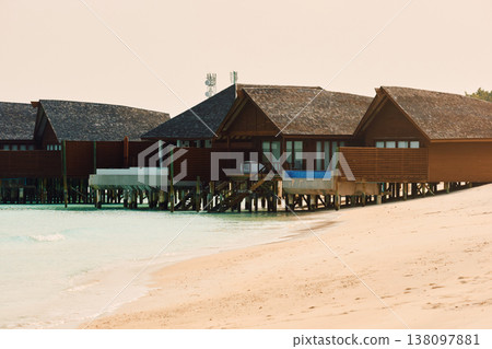 Classic Maldives island landscape on a sunset, azure water, white sand, palm trees on the shore Classic Maldives island landscape on a sunset, azure water, white sand, palm trees on the shore 138097881