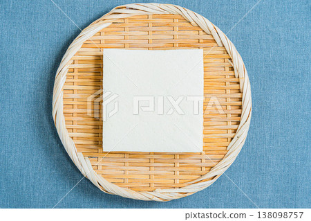 放在篩子上的硬豆腐。桌上擺放著日式料理的食材。 放在篩子上的硬豆腐。桌上擺放著日式料理的食材。 138098757