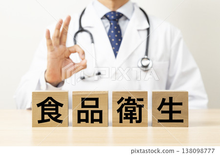 A doctor making an OK sign with a block that says "Food Hygiene" A doctor making an OK sign with a block that says "Food Hygiene" 138098777