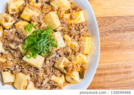 Mapo Tofu, Chinese food served on a white plate, home-style cooking on a wooden table. 138099466