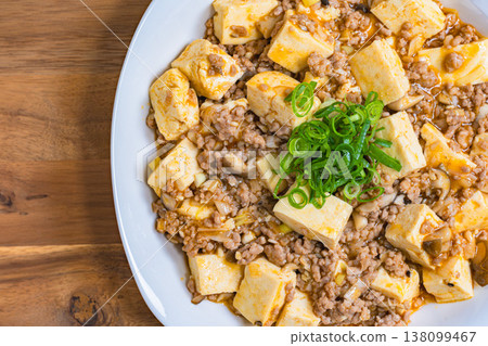 Mapo Tofu, Chinese food served on a white plate, home-style cooking on a wooden table. Mapo Tofu, Chinese food served on a white plate, home-style cooking on a wooden table. 138099467