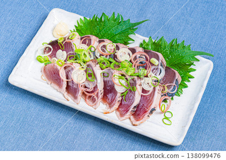 炙烤鰹魚片配上調味料,是一道日式刺身料理。 炙烤鰹魚片配上調味料,是一道日式刺身料理。 138099476