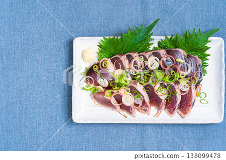 The presentation of seared bonito, topped with condiments, is a Japanese sashimi dish. The presentation of seared bonito, topped with condiments, is a Japanese sashimi dish. 138099478