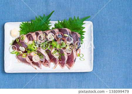 炙烤鰹魚片配上調味料,是一道日式刺身料理。 炙烤鰹魚片配上調味料,是一道日式刺身料理。 138099479