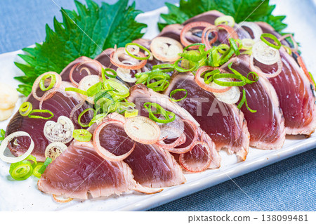 The presentation of seared bonito, topped with condiments, is a Japanese sashimi dish. The presentation of seared bonito, topped with condiments, is a Japanese sashimi dish. 138099481