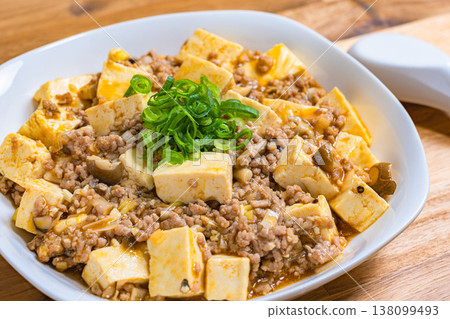Mapo Tofu, Chinese food served on a white plate, home-style cooking on a wooden table. Mapo Tofu, Chinese food served on a white plate, home-style cooking on a wooden table. 138099493