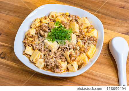 Mapo Tofu, Chinese food served on a white plate, home-style cooking on a wooden table. Mapo Tofu, Chinese food served on a white plate, home-style cooking on a wooden table. 138099494