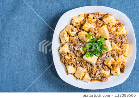 麻婆豆腐：用白色盤子盛裝的中國菜；餐桌上的家常菜。 138099500