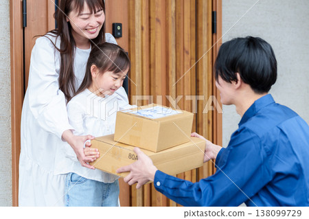 A girl receiving a package and her mother 138099729