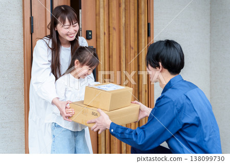 A girl receiving a package and her mother A girl receiving a package and her mother 138099730