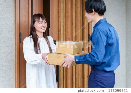 一位女士從快遞員手中接過包裹 138099831