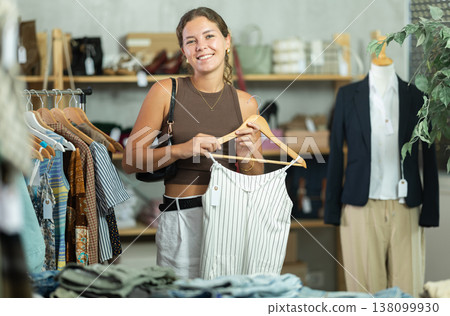 Young woman choosing a dress in a clothing store Young woman choosing a dress in a clothing store 138099930